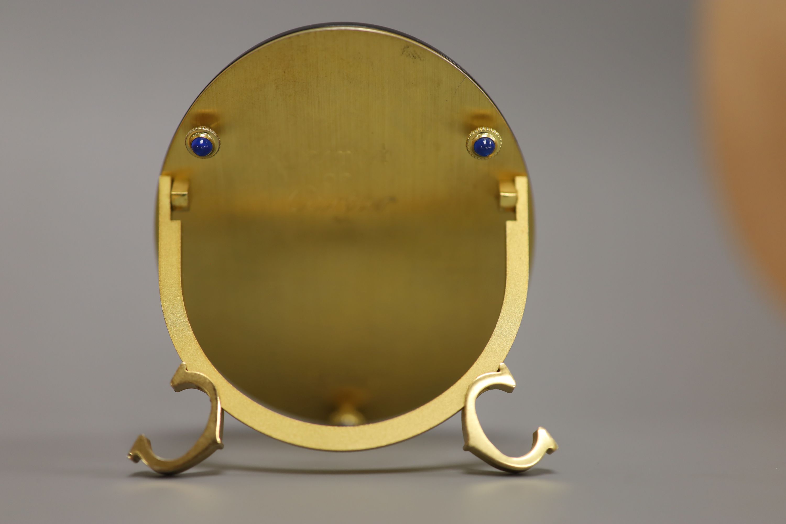 A Must de Cartier black lacquered and gilt oval easel photograph frame, length 9cm